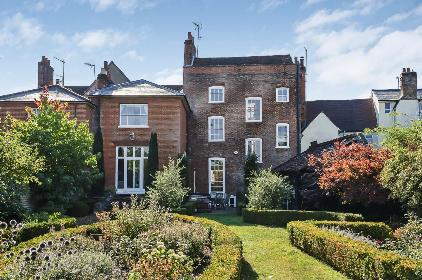 Rear elevation of the red-brick period townhouse in Hertford, seen from its walled garden